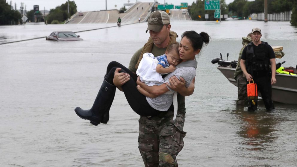 PHOTO: Houston Police SWAT officer Daryl Hudeck carries Catherine Pham and her 13-month-old son Aiden after rescuing them from their home surrounded by floodwaters from Tropical Storm Harvey, Aug. 27, 2017, in Houston. 