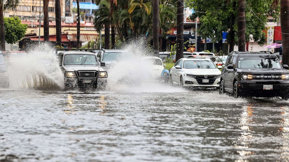 PHOTO: Cars move on a flooded street due to heavy rains in the resort of Acapulco, Guerrero state, Mexico, on Aug. 16, 2023.
