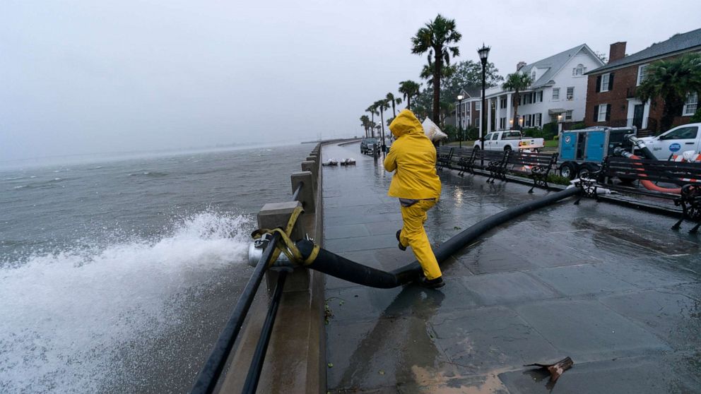PHOTO: A worker moves a sandbag after a pump was placed to remove water from the Battery as the effects from Hurricane Ian are felt, Sept. 30, 2022, in Charleston, S.C.