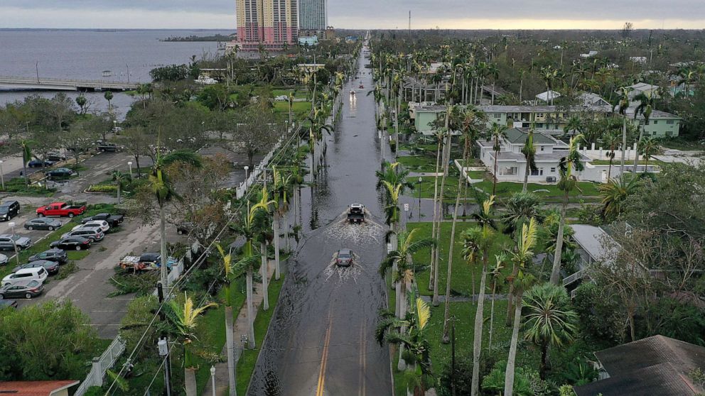 PHOTO: Vehicles make their way through a flooded area after Hurricane Ian passed through the area on Sept. 29, 2022 in Fort Myers, Fla.