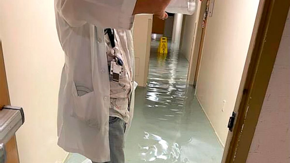 PHOTO: A staff member stands in a flooded hallway at HCA Florida Fawcett Hospital in Port Charlotte, Fla., Sept. 28, 2022.