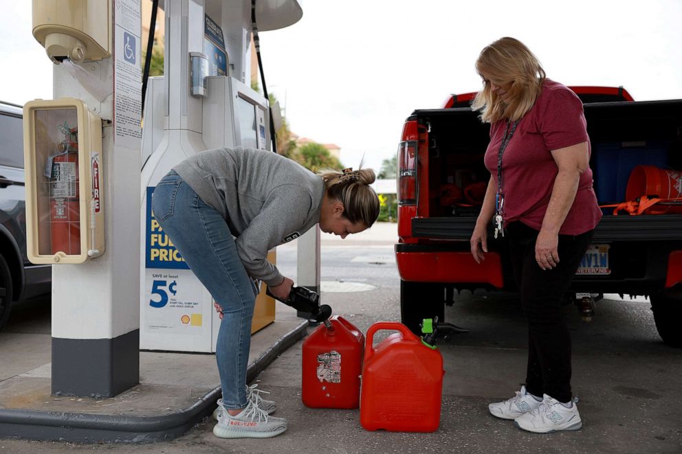 PHOTO: Brittany Andrias (L) and Cathy Dalrymple fill gas containers at a station before the possible arrival of Hurricane Ian, on Sept. 27, 2022, in St Petersburg Beach, Fla.