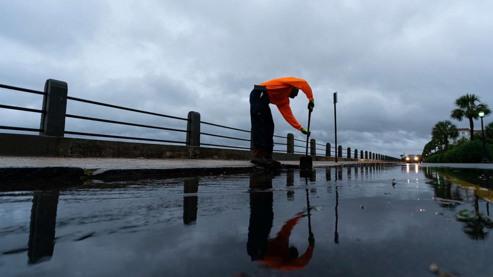 PHOTO: Corey Fields, with the city of Charleston, cleans a storm drain as effects from Hurricane Ian are felt, Sept. 30, 2022, in the Battery of Charleston, S.C.