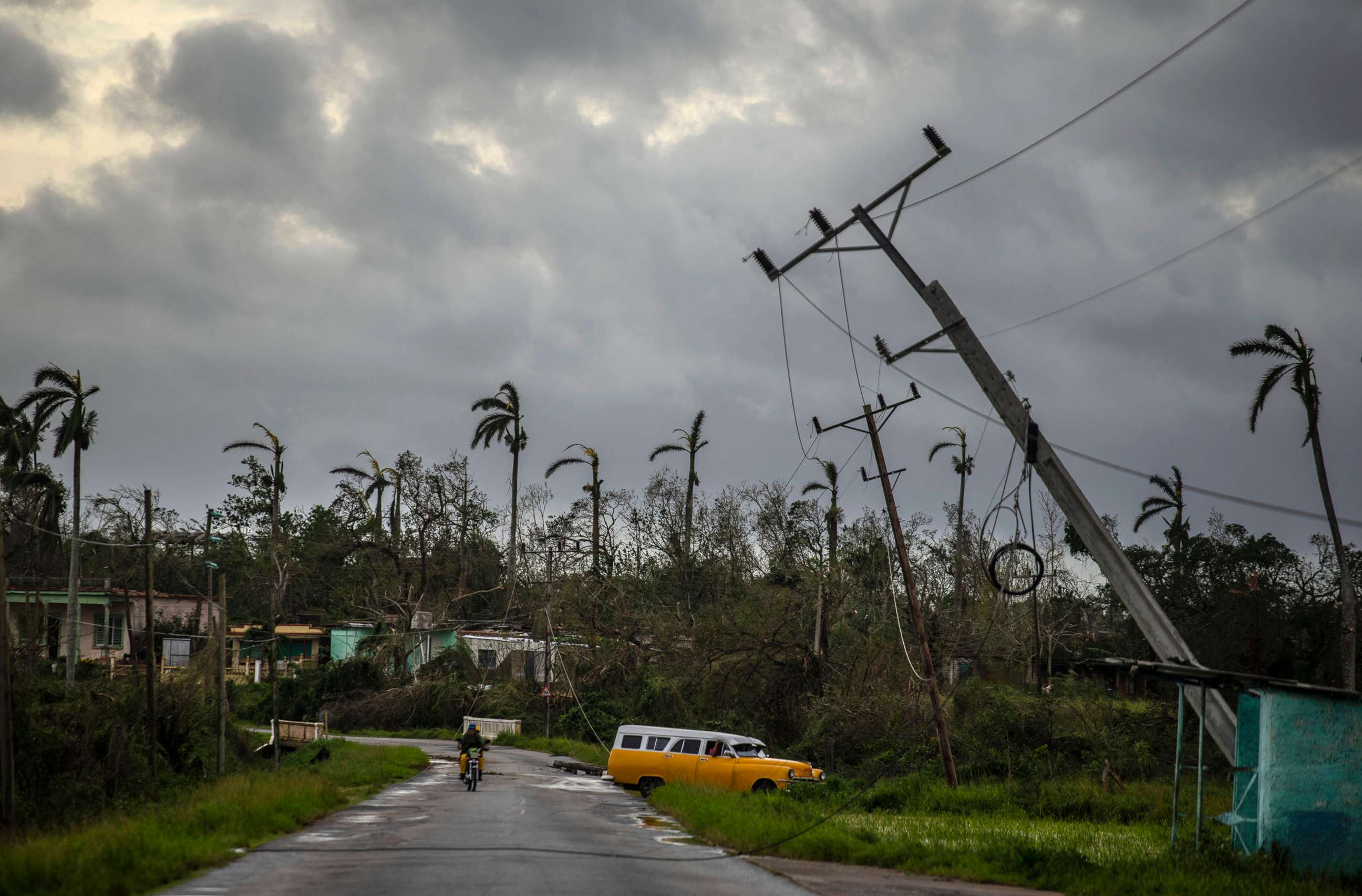 PHOTO: A classic American car drives past utility poles tilted by Hurricane Ian in Pinar del Rio, Cuba, Sept. 27, 2022.