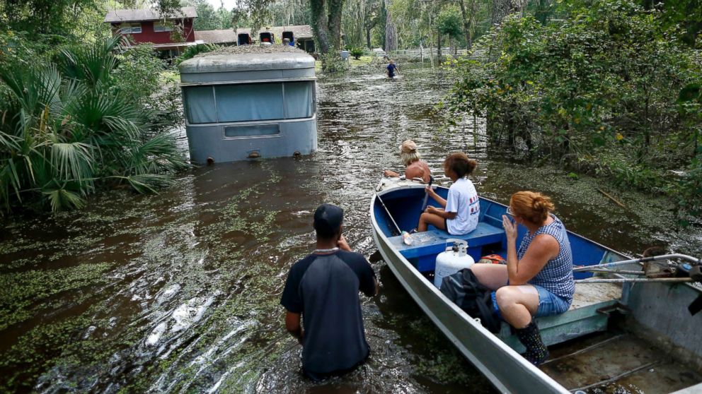 PHOTO: Family members ride in a small boat as Tony Holt's trailer is pulled out of the flood waters from Hurricane Irma in Gainesville, Florida, Sept. 14, 2017, after Hurricane Irma.