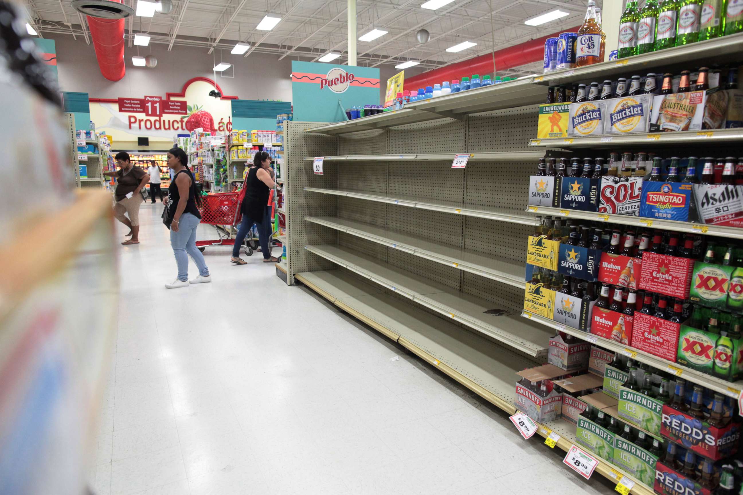 PHOTO: Customers walk near empty shelves that are normally filled with bottles of water after Puerto Rico Governor Ricardo Rossello declared a state of emergency in preparation for Hurricane Irma, in San Juan, Puerto Rico, Sept. 4, 2017. 