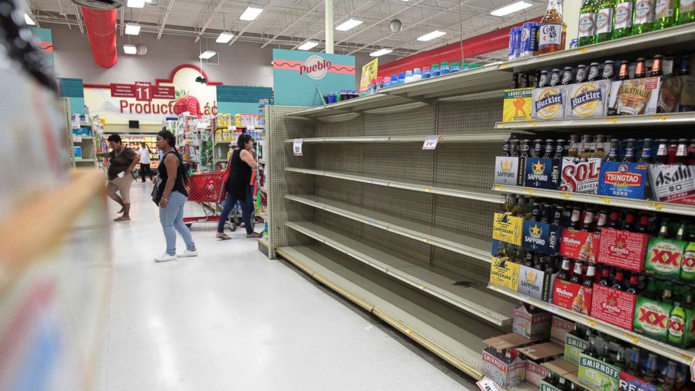 PHOTO: Customers walk near empty shelves that are normally filled with bottles of water after Puerto Rico Governor Ricardo Rossello declared a state of emergency in preparation for Hurricane Irma, in San Juan, Puerto Rico, Sept. 4, 2017. 