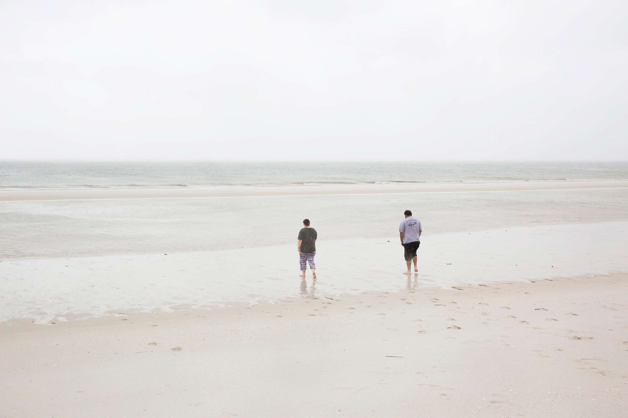 PHOTO: Cory Salmon, right, and his daughter Corrie, walk on Vanderbilt Beach where the water has recessed significantly into the Gulf of Mexico, Sept. 10, 2017, in Naples, Fla. 