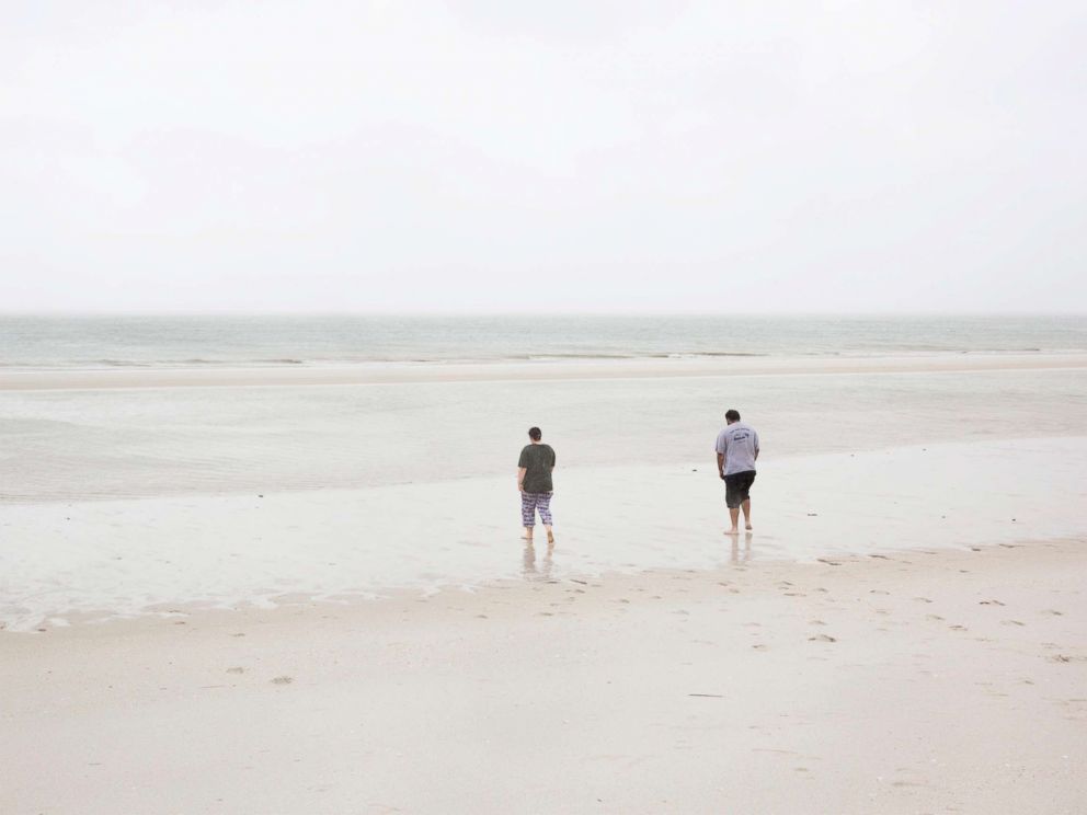 PHOTO: Cory Salmon, right, and his daughter Corrie, walk on Vanderbilt Beach where the water has recessed significantly into the Gulf of Mexico, Sept. 10, 2017, in Naples, Fla.