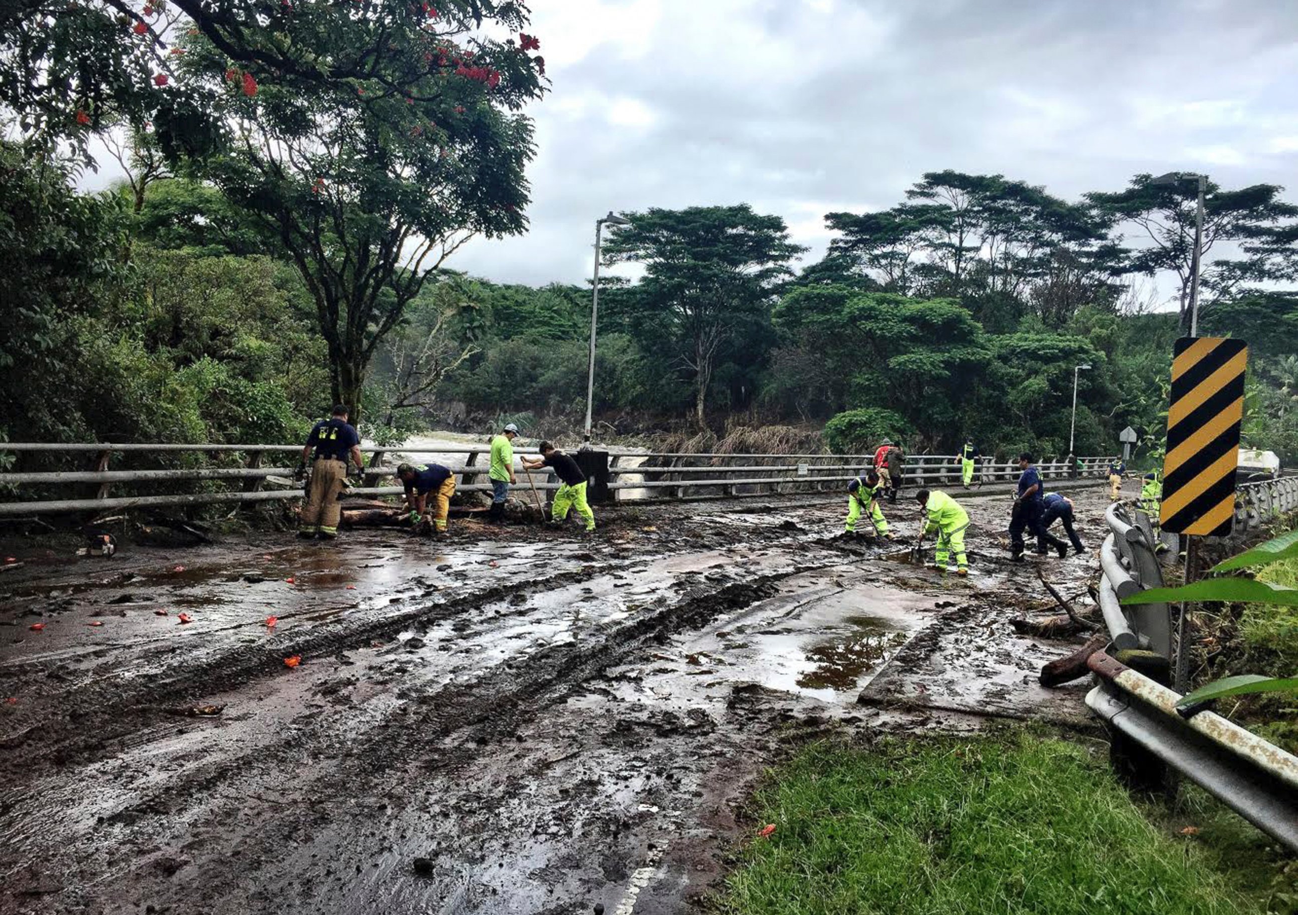 In this photo provided by Jessica Henricks, crews work at clearing damage from Hurricane Lane Friday, Aug. 24, 2018, near Hilo, Hawaii.