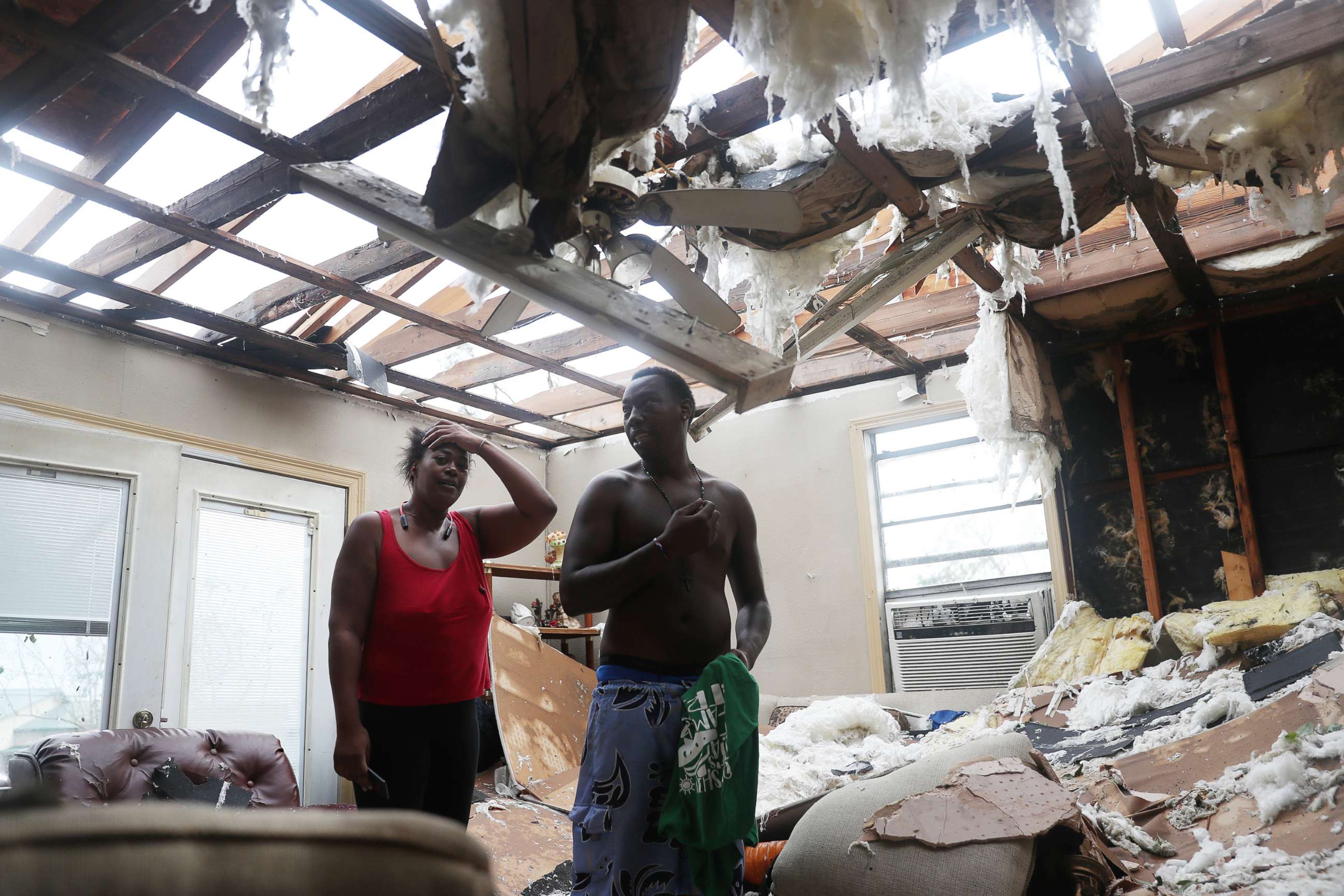 PHOTO: Latasha Myles and Howard Anderson stand in their living room where they were sitting when the roof blew off around 2:30am  in Lake Charles, La. , Aug. 27, 2020.