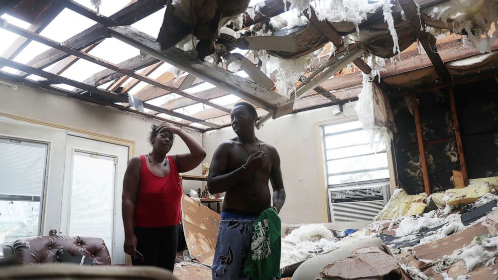 PHOTO: Latasha Myles and Howard Anderson stand in their living room where they were sitting when the roof blew off around 2:30am  in Lake Charles, La. , Aug. 27, 2020.