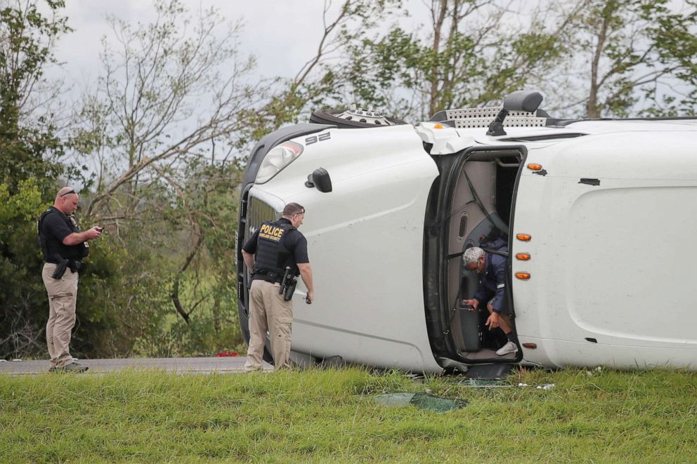 PHOTO: The driver of an overturned 18 wheeler truck exits his vehicle after police arrival to the scene in the aftermath of Hurricane Laura along I-10 in Vinton, La., Aug. 27, 2020.