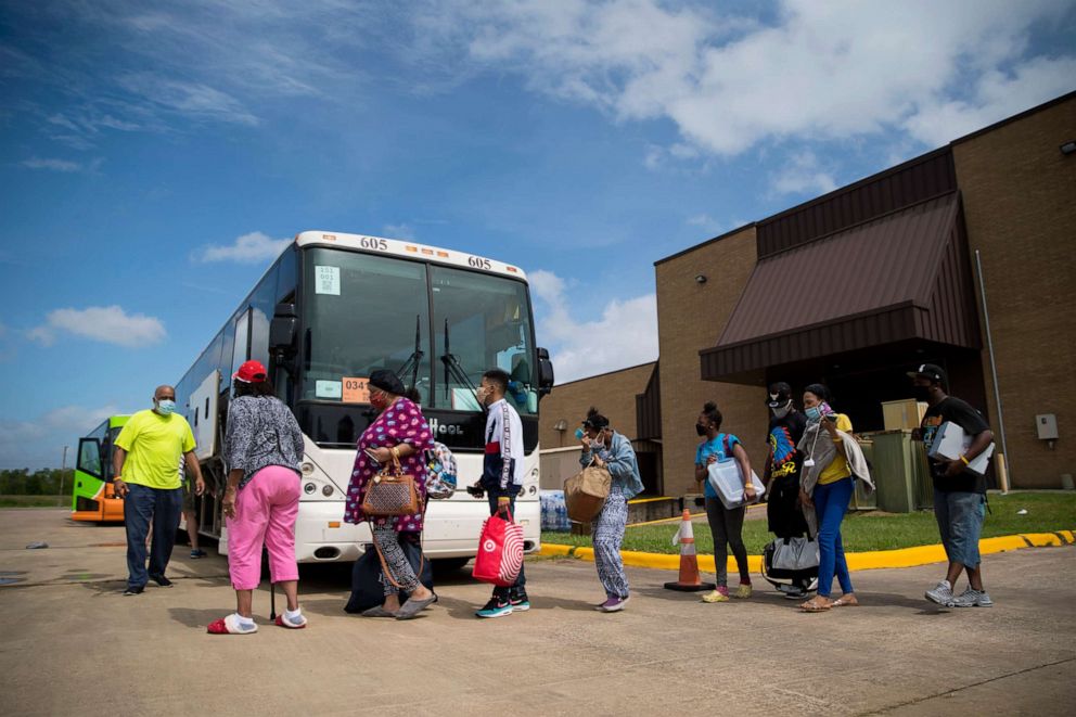 PHOTO: People board buses at the Port Arthur Civic Center to evacuate the city ahead of Hurricane Laura, Aug. 26, 2020, in Port Arthur, Texas.
