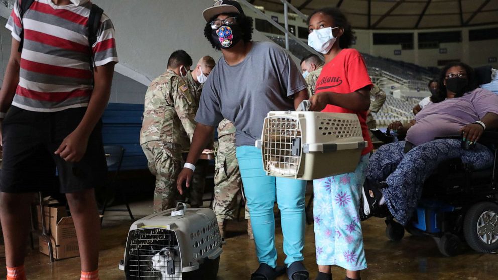 Evacuees wait to board a bus as they are evacuated by local and state government officials before the arrival of Hurricane Laura, Aug. 26, 2020, in Lake Charles, Louisiana.