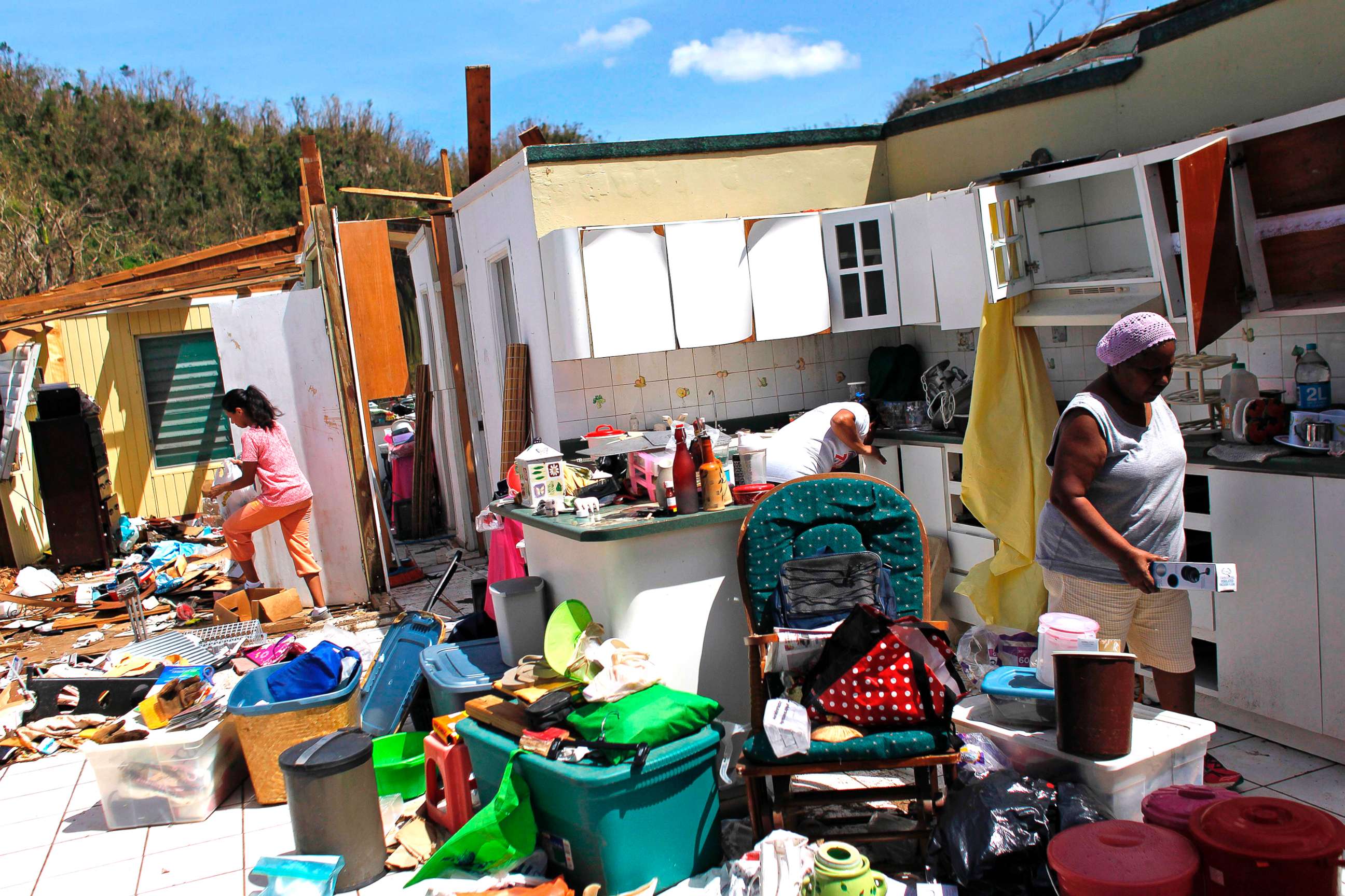 PHOTO: Family members collect their belongings after hurricane force winds destroyed their house in Toa Baja, west of San Juan, Puerto Rico, on Sept. 24, 2017.