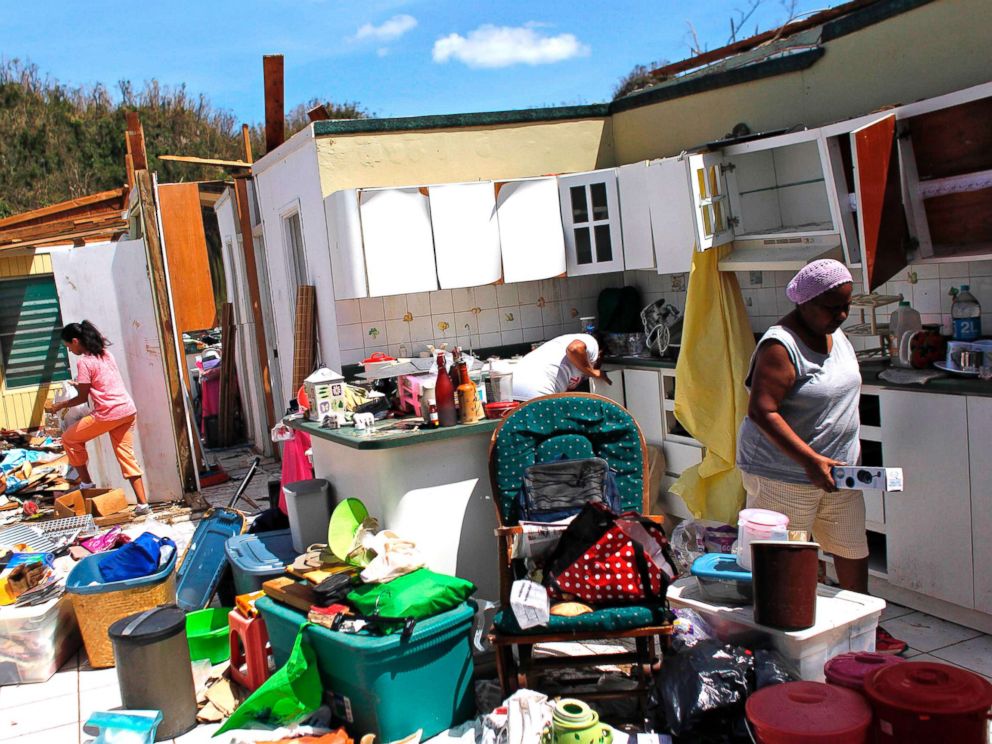 PHOTO: Family members collect their belongings after hurricane force winds destroyed their house in Toa Baja, west of San Juan, Puerto Rico, on Sept. 24, 2017.