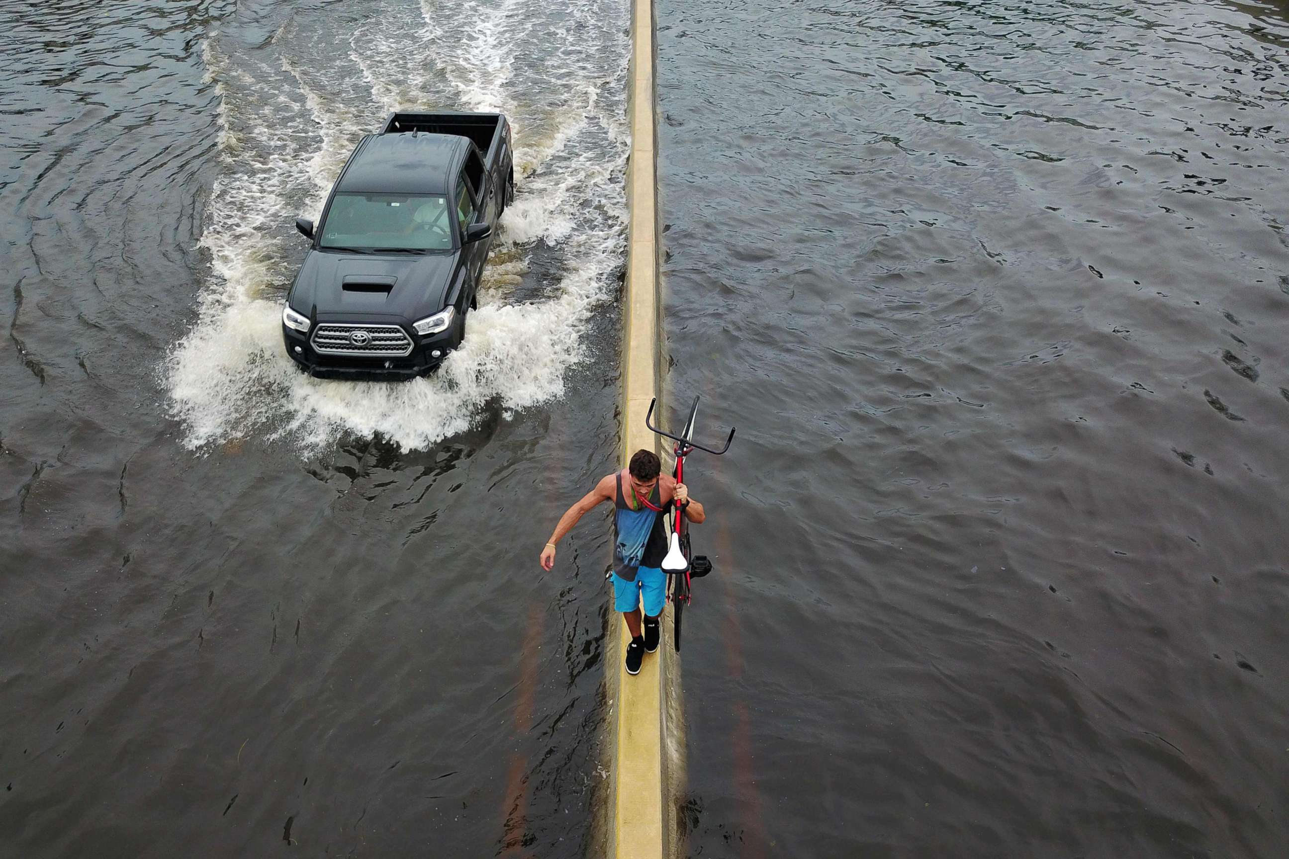 PHOTO:A man walks on a highway divider while carrying his bicycle in the aftermath of Hurricane Maria in San Juan, Puerto Rico, Sept. 21, 2017.