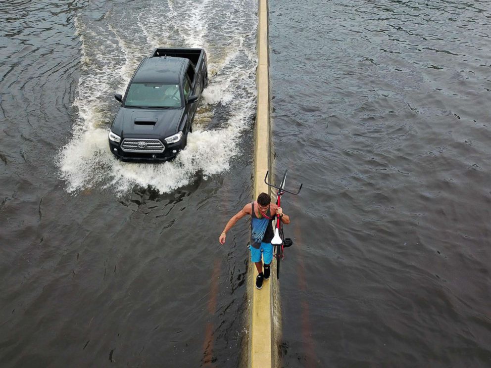 PHOTO:A man walks on a highway divider while carrying his bicycle in the aftermath of Hurricane Maria in San Juan, Puerto Rico, Sept. 21, 2017.