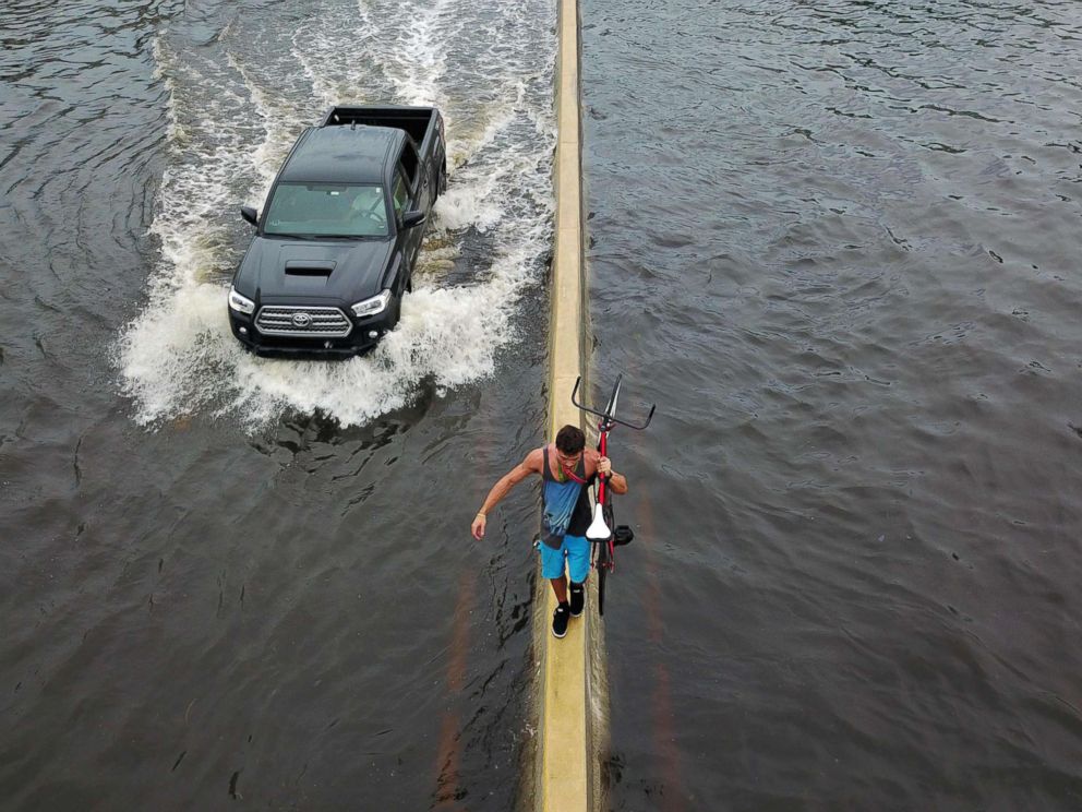 PHOTO:A man walks on a highway divider while carrying his bicycle in the aftermath of Hurricane Maria in San Juan, Puerto Rico, Sept. 21, 2017.