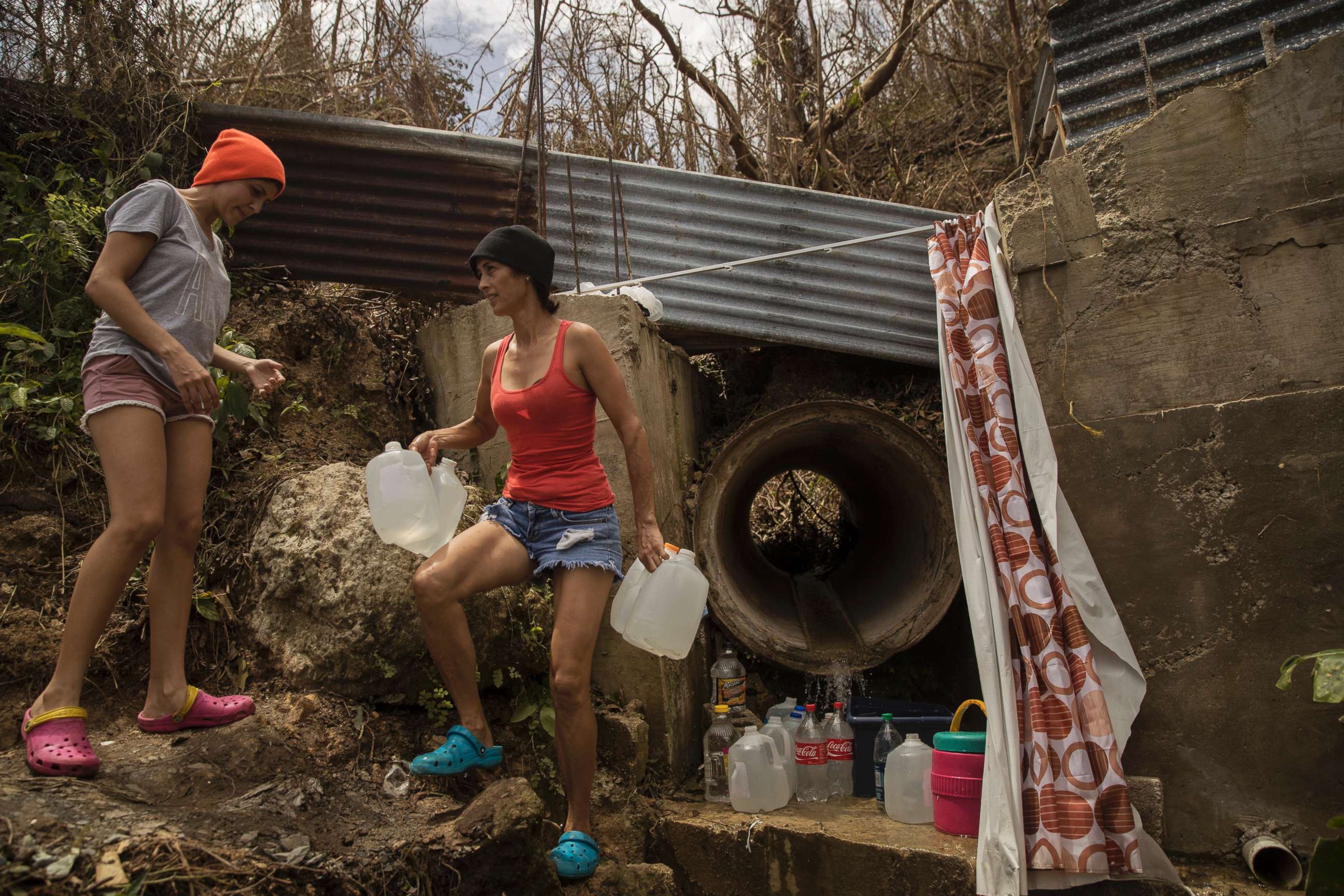 PHOTO: Yamilex Virella and her mother-in-law, Norma Andreu, carry water from a natural spring in the hill town of Toa Alta, Puerto Rico, Sept. 25, 2017.