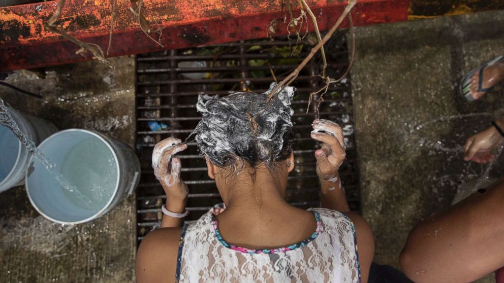PHOTO: A woman washes her hair in a natural spring in the hill town of Toa Alta, Puerto Rico, Sept. 25, 2017. 