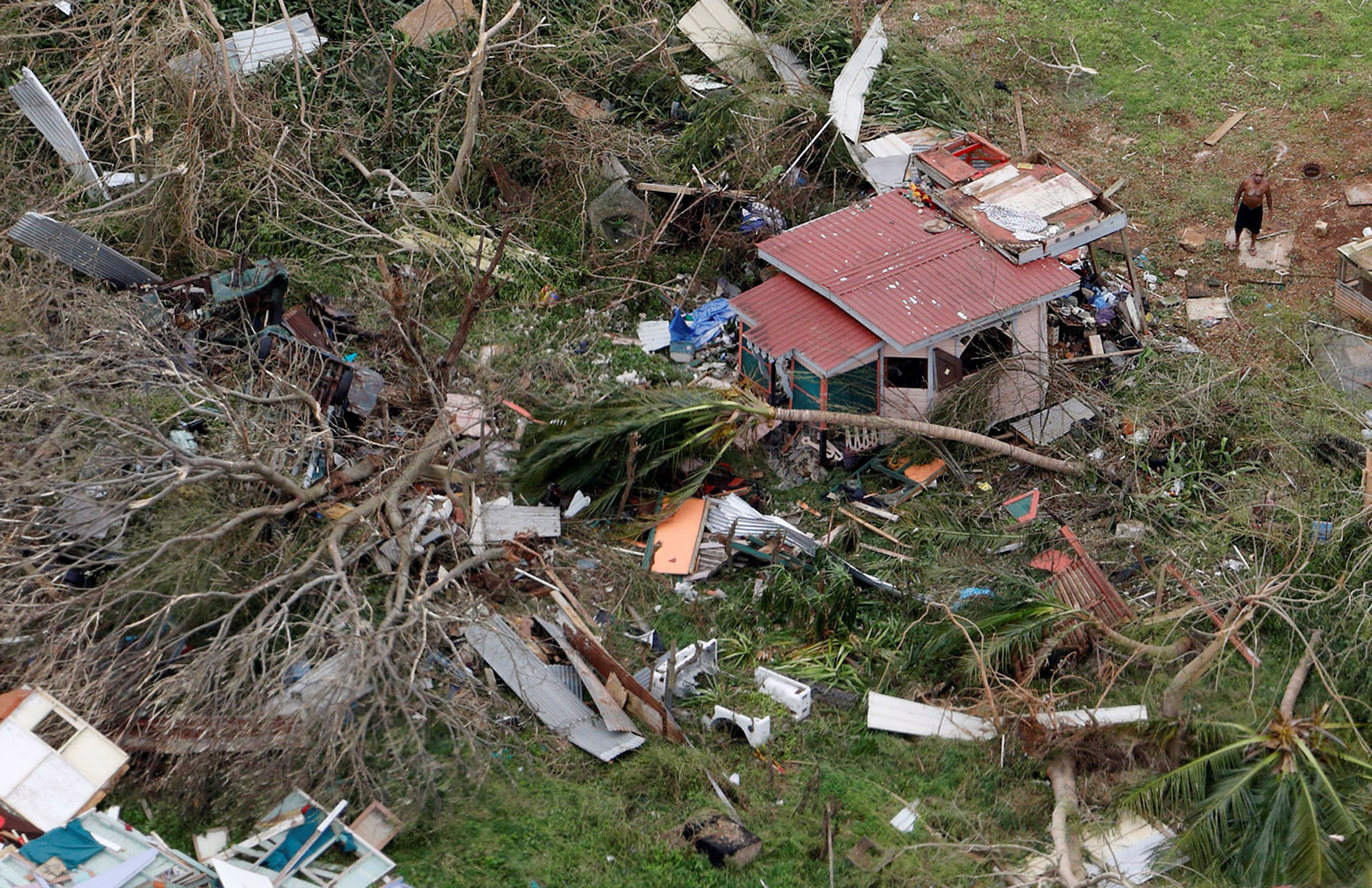 PHOTO: A man stands outside a destroyed home in this aerial photo from a Marine Corps MV-22 Osprey surveying the aftermath from Hurricane Maria in St. Croix, U.S. Virgin Islands, Sept. 21, 2017. 