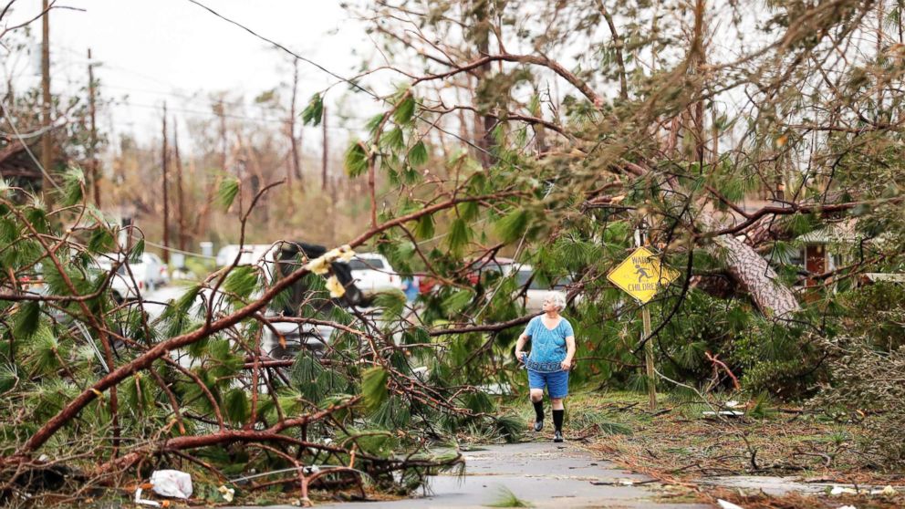 PHOTO: A woman walks through downed trees blocking her heavily damaged neighborhood just after Hurricane Michael passed through in Panama City, Fla., Oct. 10, 2018.