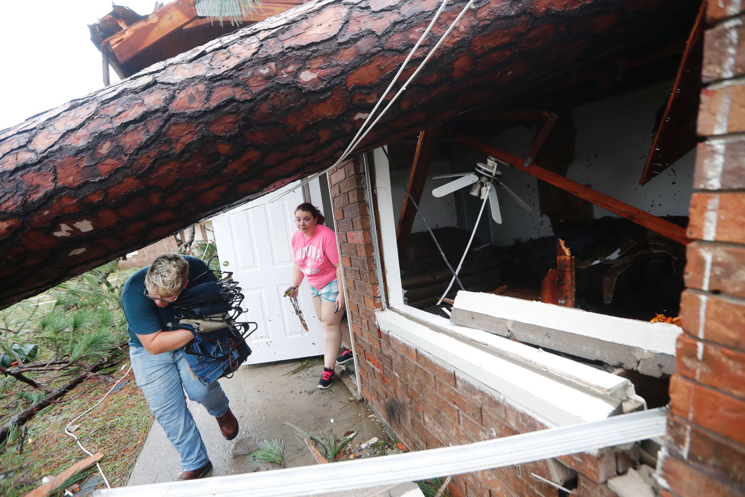 PHOTO: People take belongings from their destroyed home after several trees fell on the house during Hurricane Michael in Panama City, Fla., Oct. 10, 2018.
