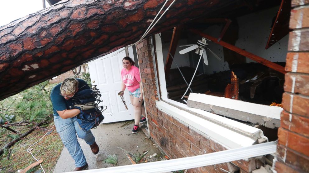 PHOTO: People take belongings from their destroyed home after several trees fell on the house during Hurricane Michael in Panama City, Fla., Oct. 10, 2018.