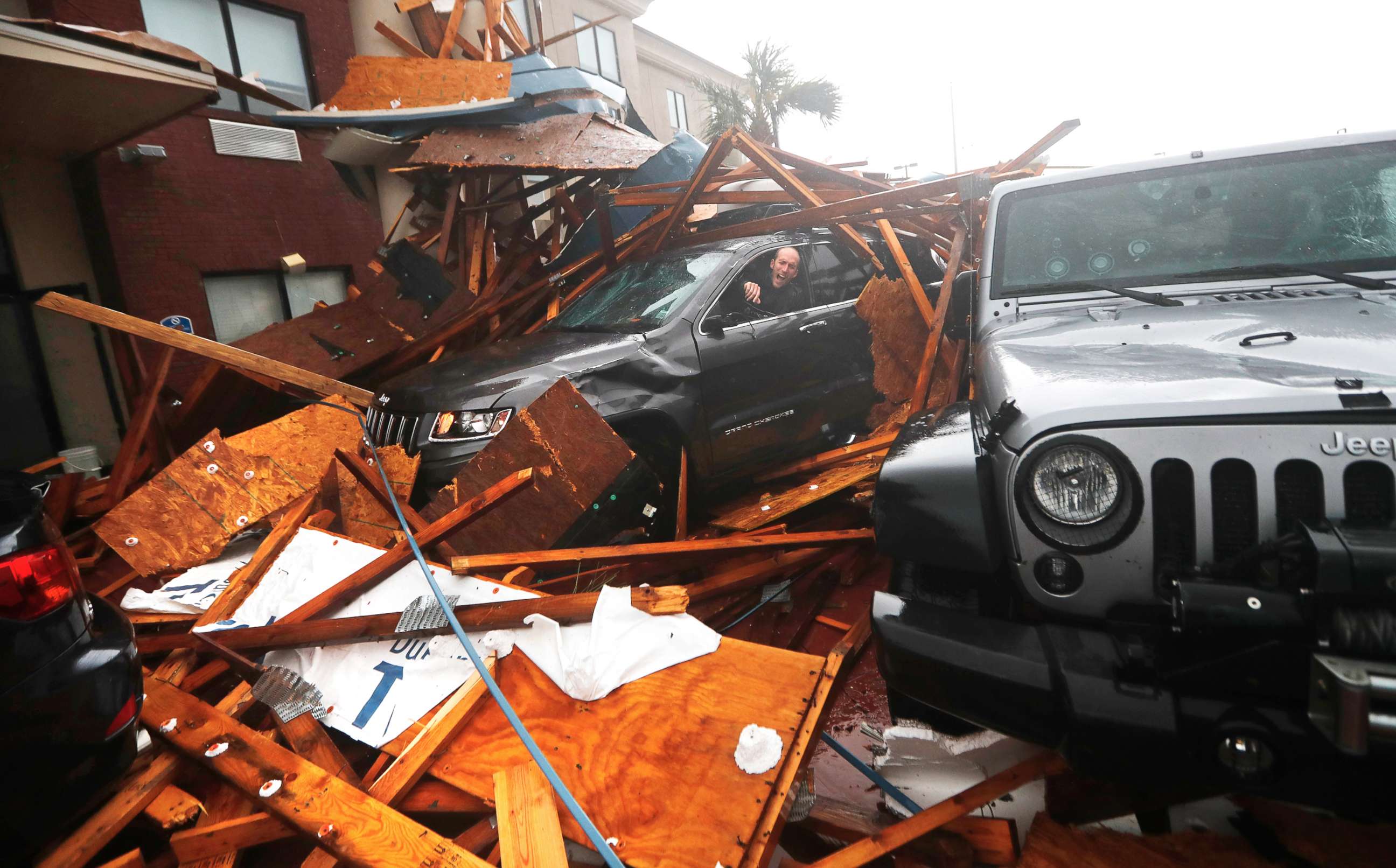 PHOTO: A storm chaser climbs into his vehicle during the eye of Hurricane Michael to retrieve equipment after a hotel canopy collapsed in Panama City Beach, Fla., Oct. 10, 2018.