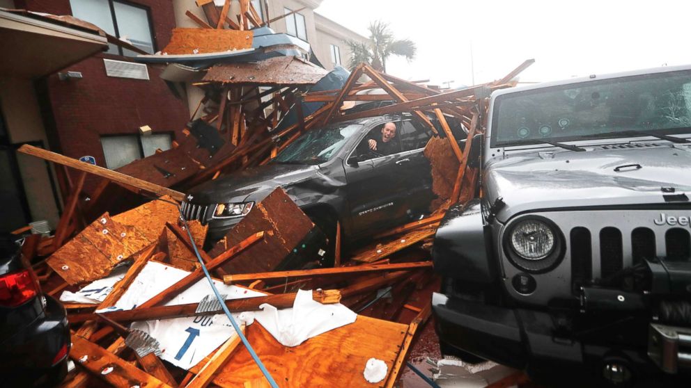 PHOTO: A storm chaser climbs into his vehicle during the eye of Hurricane Michael to retrieve equipment after a hotel canopy collapsed in Panama City Beach, Fla., Oct. 10, 2018.