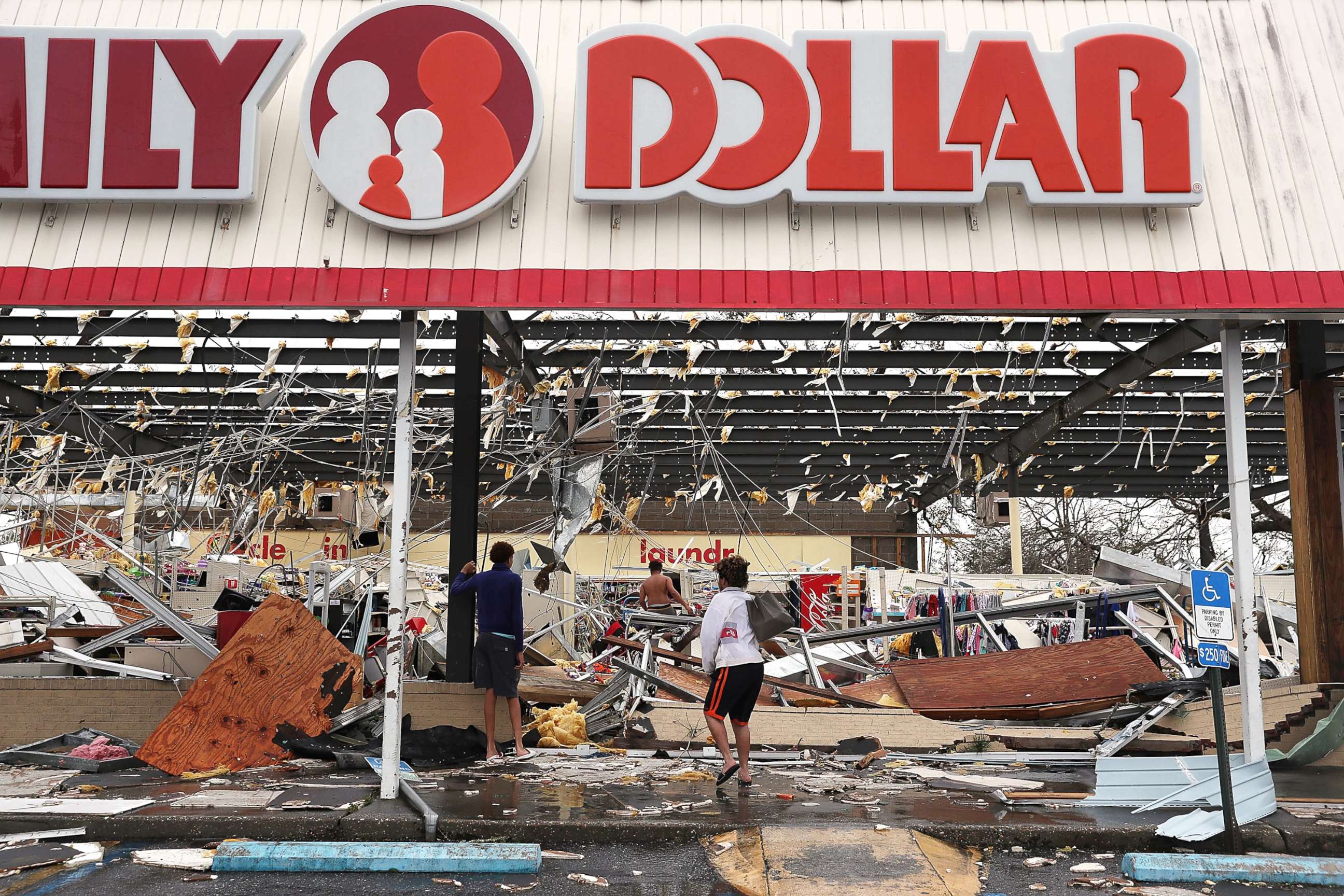 PHOTO: People look on at a damaged store after Hurricane Michael passed through on Oct. 10, 2018, in Panama City, Fla.