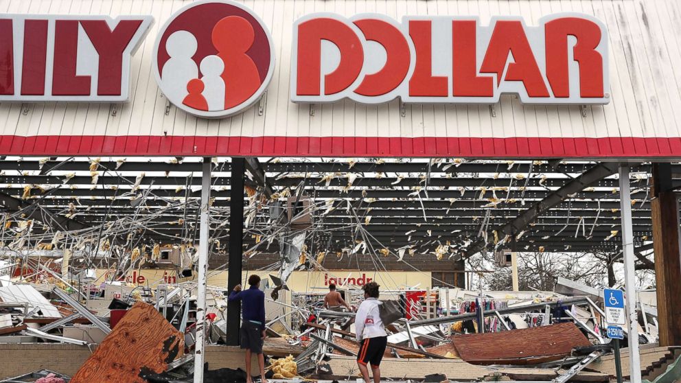 PHOTO: People look on at a damaged store after Hurricane Michael passed through on Oct. 10, 2018, in Panama City, Fla.