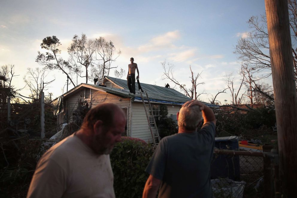 PHOTO: A man helps to tarp a roof on Oct. 18, 2018 in Panama City, Fla.