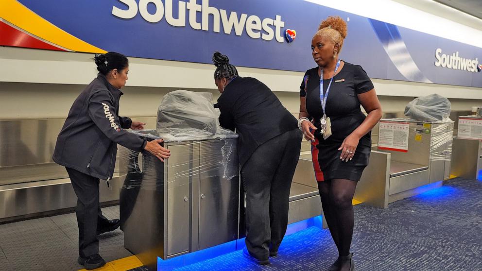 PHOTO: Southwest Airlines employees cover the ticket counters with plastic wrap just before Tampa International Airport was closing due to the possible arrival of Hurricane Milton, Oct. 8, 2024, in Tampa, Fla. 