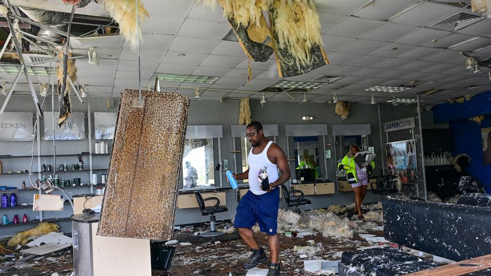 PHOTO: Employees collect some of their belongings from a beauty salon that was destroyed by the intense tornado that hit Cocoa Beach, Fla., on Oct. 10, 2024.