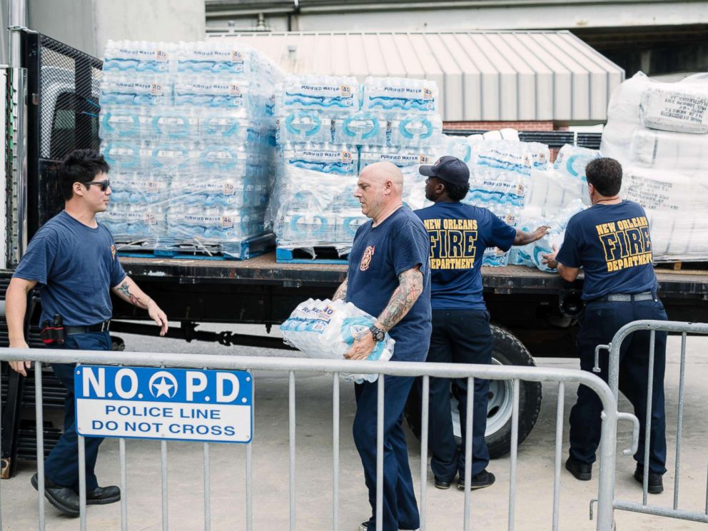 PHOTO: Firefighters Stan Ho (L) and Richard Jensen (C) unload supplies for the people of New Orleans in preparation of Hurricane Nate in New Orleans, Oct. 7, 2017.