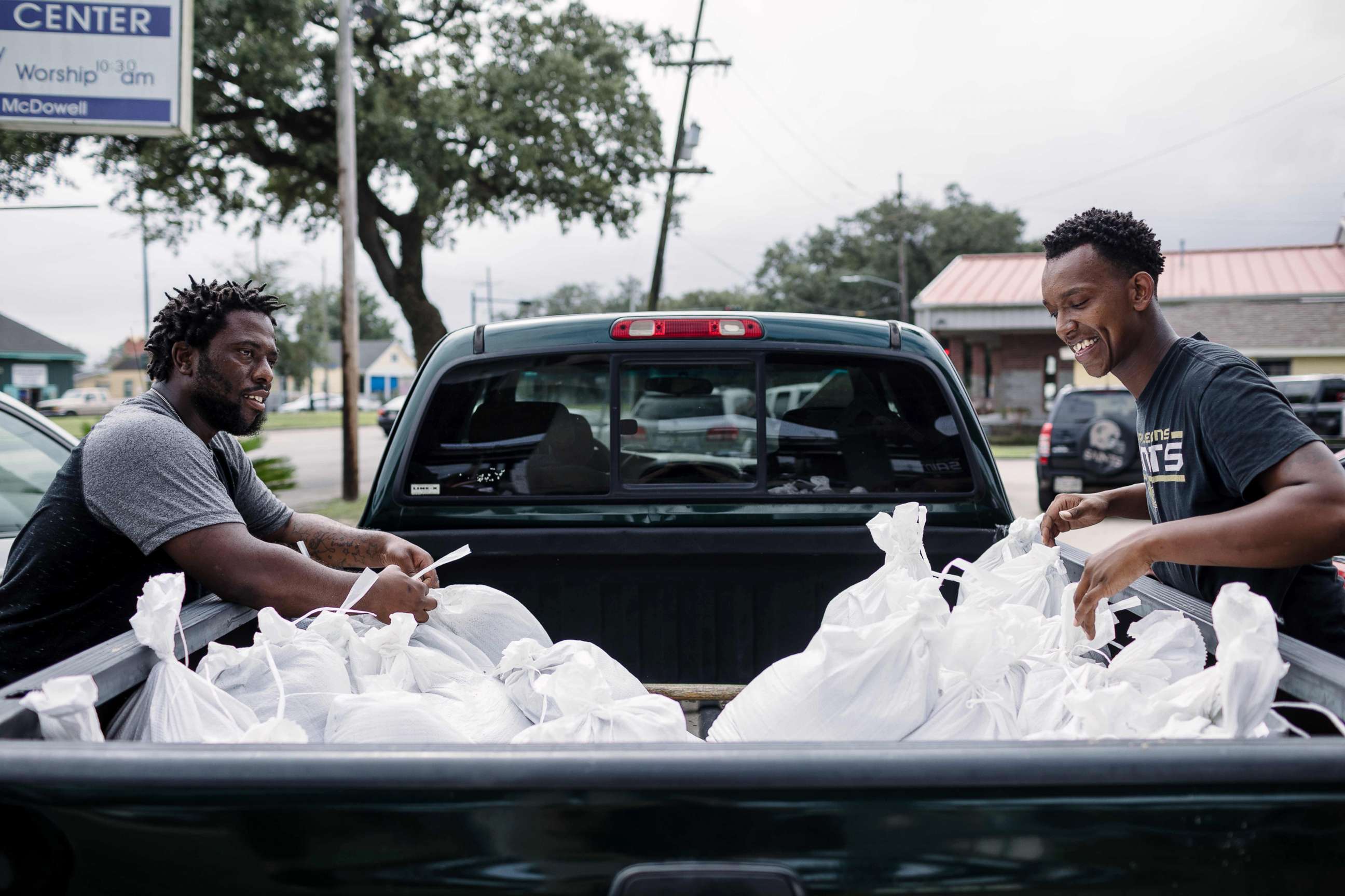 PHOTO: Percy Harrison (L) and Jeramie Moliere load sandbags into the back of a truck to bring to people who live in the neighborhood surrounding their church in preparation for Hurricane Nate in New Orleans, Oct. 7, 2017.