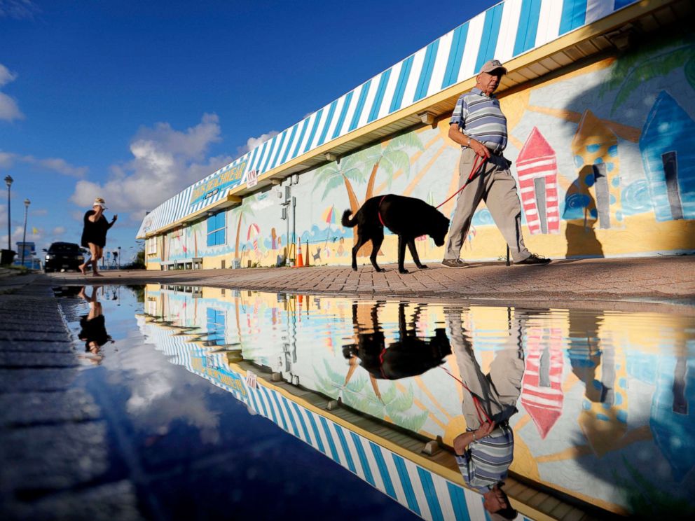 PHOTO: Beachgoers walk past a mural along the boardwalk as Hurricane Florence approaches the east coast in Atlantic Beach, N.C., Sept. 12, 2018.