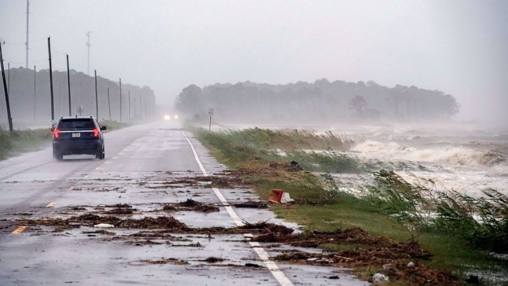 PHOTO: A car drives by crashing waves as Hurricane Sally approaches in Alabama Port, Alabama, Sept. 15, 2020.