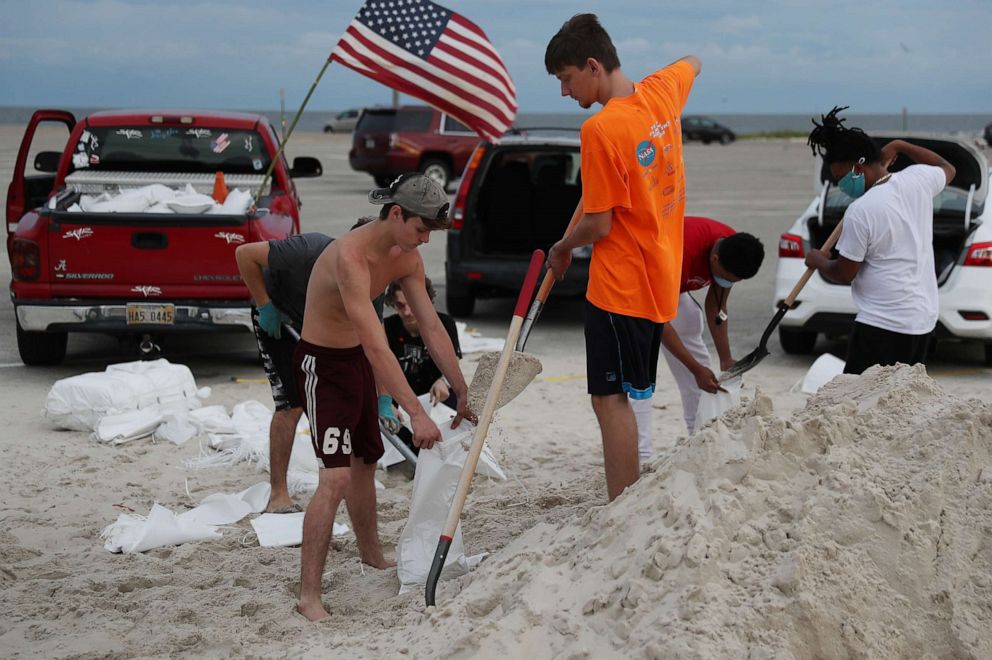 PHOTO: Left to right, Justin Roberts, Noah Dubuisson and others fill sandbags on Sept. 14, 2020, in Biloxi, Miss.