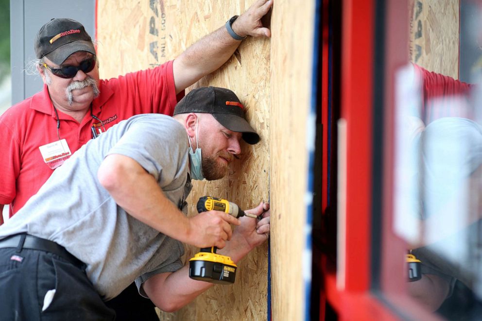 PHOTO:Alex Vidmar, center, and Darrin Manning board up a business as Hurricane Sally approaches in Ocean Springs, Miss., Sept. 14, 2020.