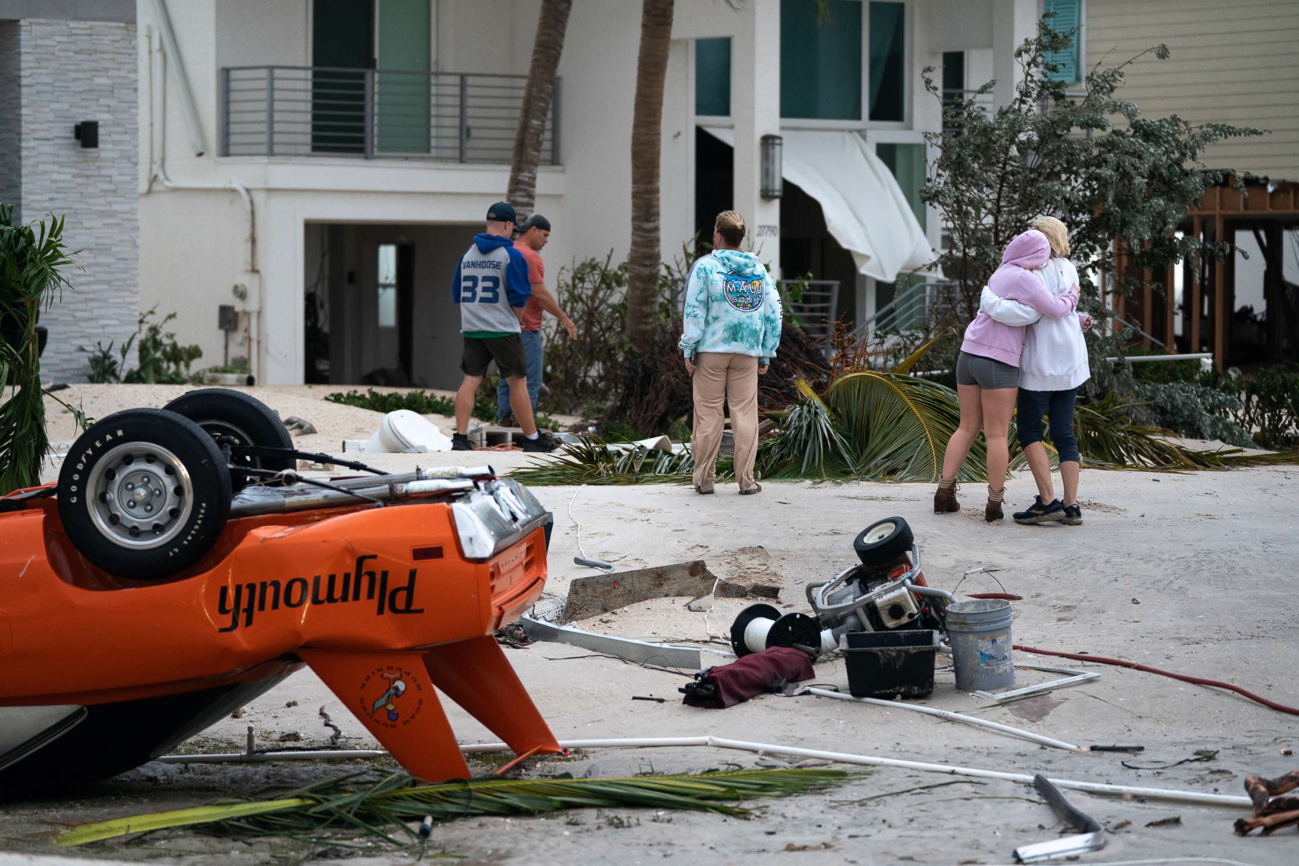 PHOTO: People embrace as they survey property damage from Hurricane Ian, Sept. 29, 2022, in Bonita Springs, Fla.