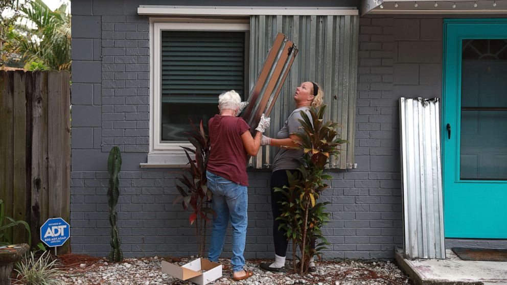 PHOTO: People place shutters on their homes as they prepare for the possible arrival of Hurricane Ian on Sept. 27, 2022 in St Petersburg, Fla. Ian is expected in the Tampa Bay area Wednesday night into early Thursday morning.