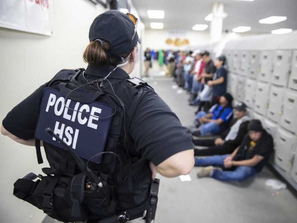 PHOTO: This image released by the US Immigration and Customs Enforcement on Aug. 7, 2019, shows a Homeland Security Investigations officer guarding suspected illegal aliens in Canton, Miss.