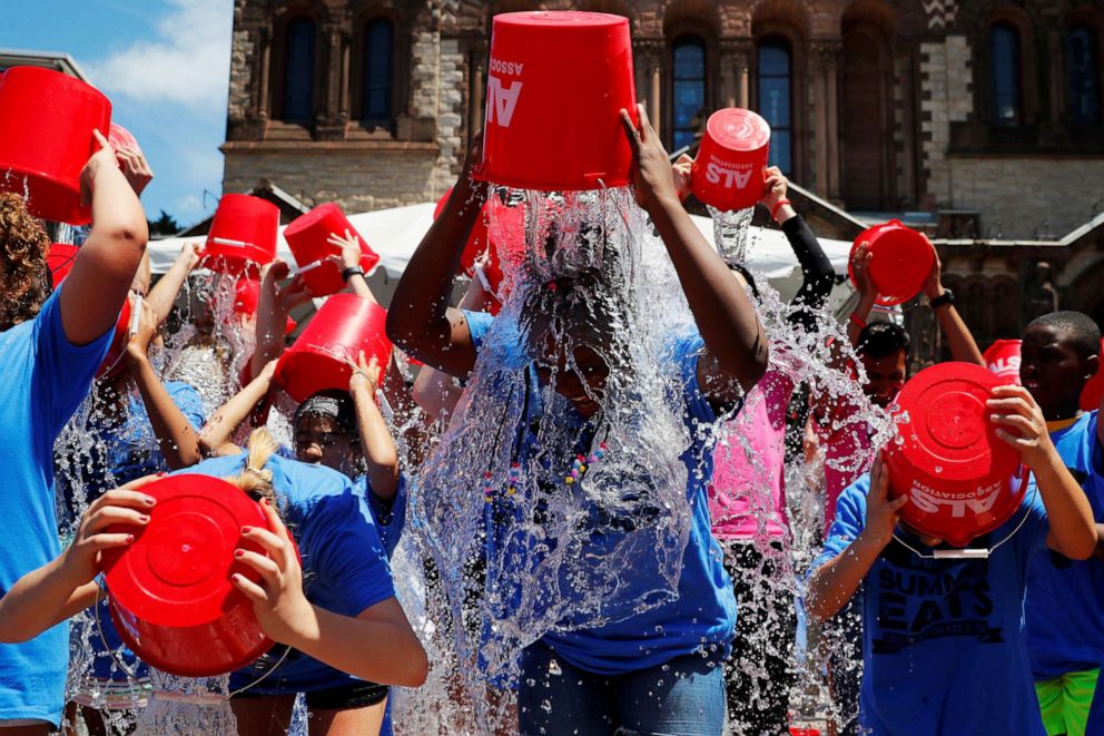 PHOTO: In this July 15, 2019, file photo, eleven-year-old Jahziyah Jones, with a crowd of others, pours a bucket of ice water over her head during an event to commemorate the five year anniversary of the "ALS Ice Bucket Challenge," in Boston.