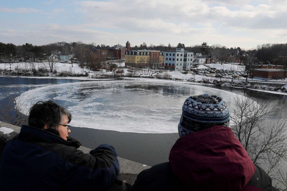 PHOTO: Onlookers watch a large, circular ice floe spinning slowly in the Presumpscot River in Westbrook, Maine, Jan. 16, 2019.