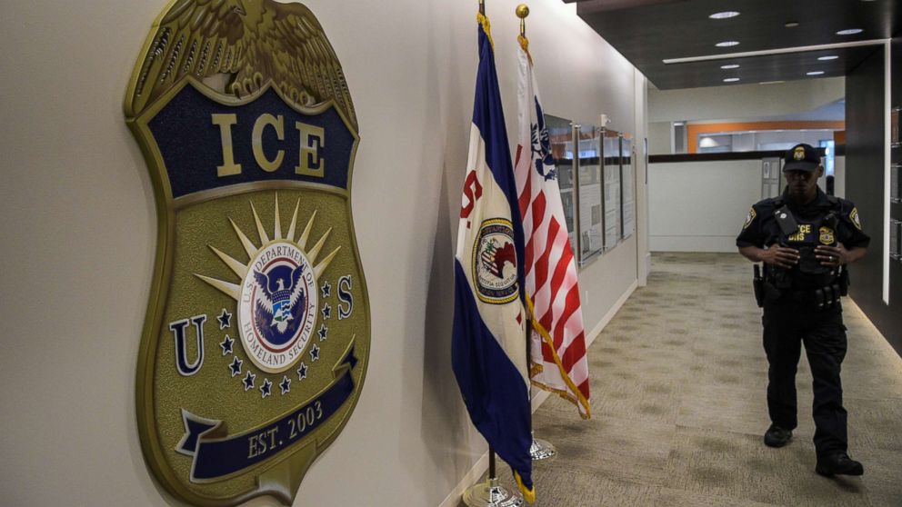 A law enforcement officer walks past ICE logo on May 11, 2017, at the U.S. Immigration and Customs Enforcement headquarters in Washington, D.C.
