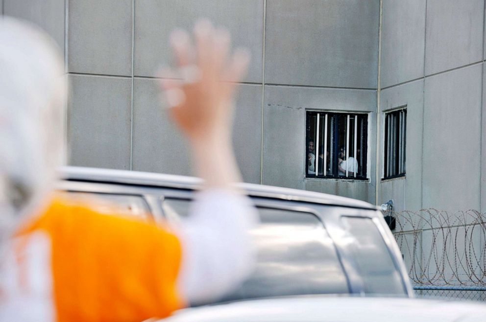 PHOTO: A protester waves to detainees at the Strafford County Detention Center where ICE detainees are being held in Dover, N.H., Aug. 24, 2019.